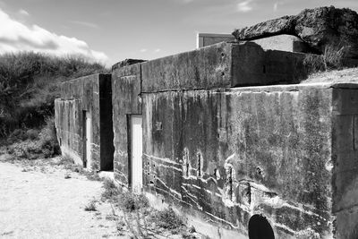 Old abandoned building on field against sky