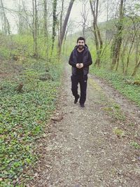 Full length of young man walking in forest