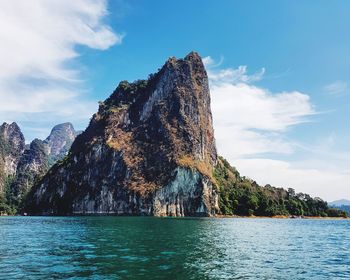 Rock formations by sea against sky