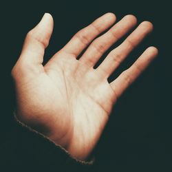 Close-up of hand holding over black background