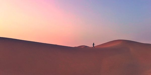 Scenic view of desert against sky during sunset