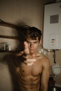 Portrait of shirtless man standing at home