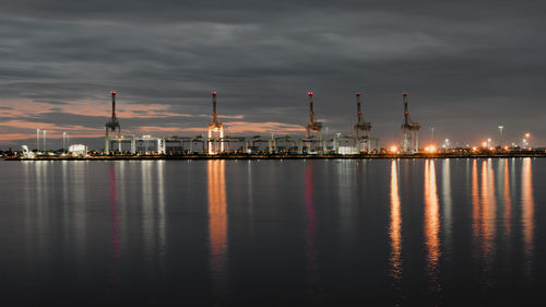 Scenic view of illuminated factory against sky