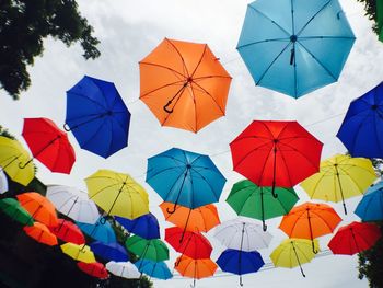 Low angle view of umbrellas hanging against sky