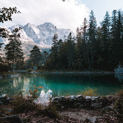 Scenic view of lake by snowcapped mountains against sky