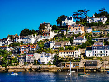 View of townscape by sea against blue sky