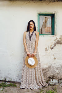 Portrait of woman standing against wall