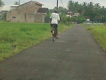 Rear view of man walking on road