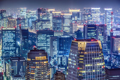 Illuminated cityscape against sky at night