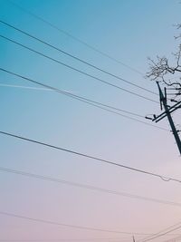 Low angle view of power cables against clear blue sky