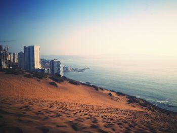 Scenic view of sea and city against clear sky