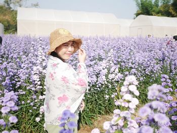 Young woman standing amidst flower field