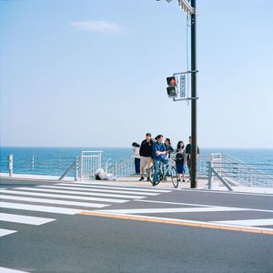 People on beach by sea against sky