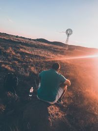 Rear view of man sitting on landscape