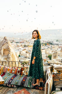 Woman at sunrise with hot air balloons rising up in cappadocia turkey