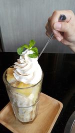 Cropped hand having ice cream on table