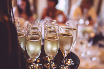 Close-up of champagne glasses on tray at restaurant