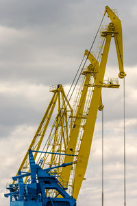 Low angle view of cranes against sky