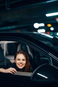 Happy woman sitting in car