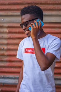 Low section of man standing on mobile phone