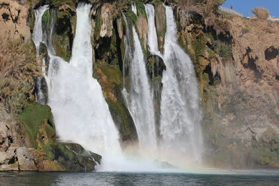 Scenic view of waterfall against sky