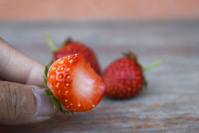 Close-up of hand holding strawberry