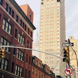 Low angle view of road sign against sky in city