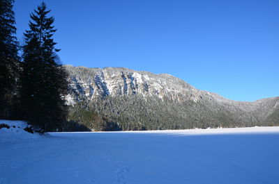 Scenic view of snowcapped mountains against clear blue sky