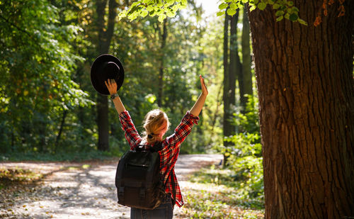 Rear view of woman standing in forest