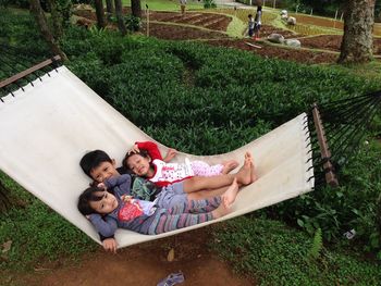 High angle view of friends lying on grass