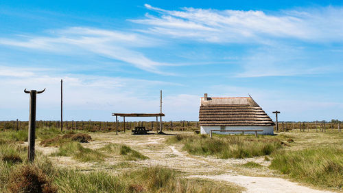 Camarguaise cabin on field against sky