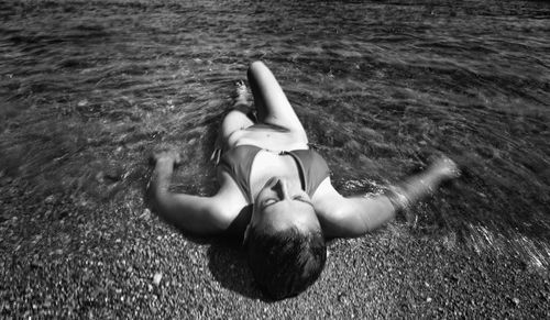 Young woman lying on sea shore