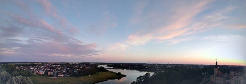 High angle view of buildings by sea against sky during sunset