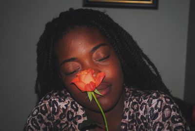 Close-up portrait of young woman with a rose