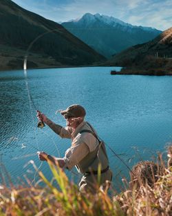 Man by lake against mountains