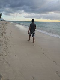 Full length rear view of man standing on beach