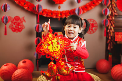 Portrait of cute girl wearing costume holding box at home