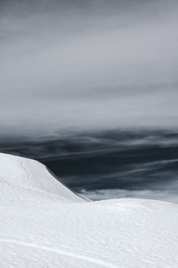 Scenic view of snow covered land against sky