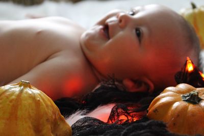Close-up of baby boy lying on bed with halloween decoration