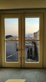 Buildings against sky seen through glass window