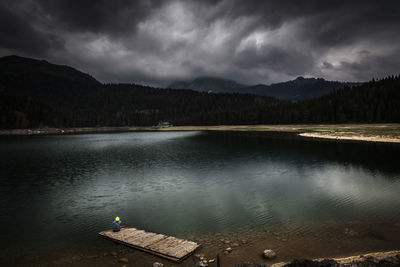 Scenic view of lake by mountains against sky