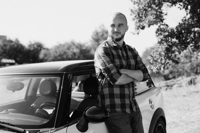 Portrait of young man standing in car