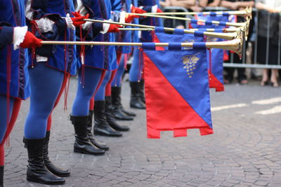 Low section of people standing with flag during parade