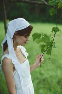 Portrait of young woman holding plant