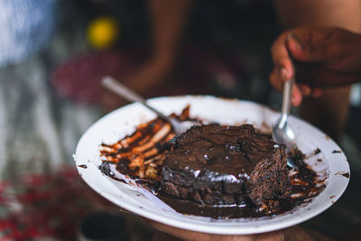 Close-up of hand holding ice cream in plate