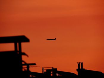 Silhouette airplane against sky during sunset