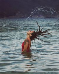 Young woman tossing hair in sea