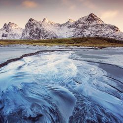 Scenic view of frozen lake against sky during sunset