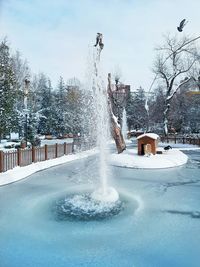 Fountain in park against sky during winter