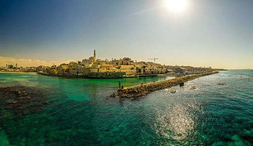 Scenic view of sea against buildings in city